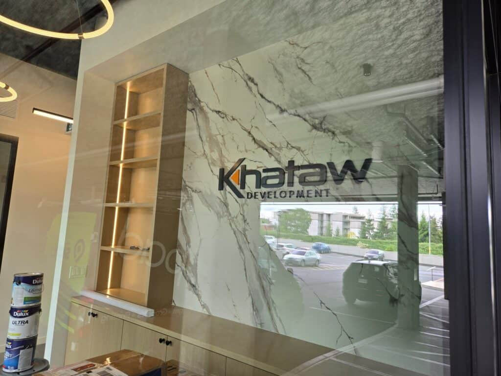 Custom Khatow Development sign on marble wall in office.