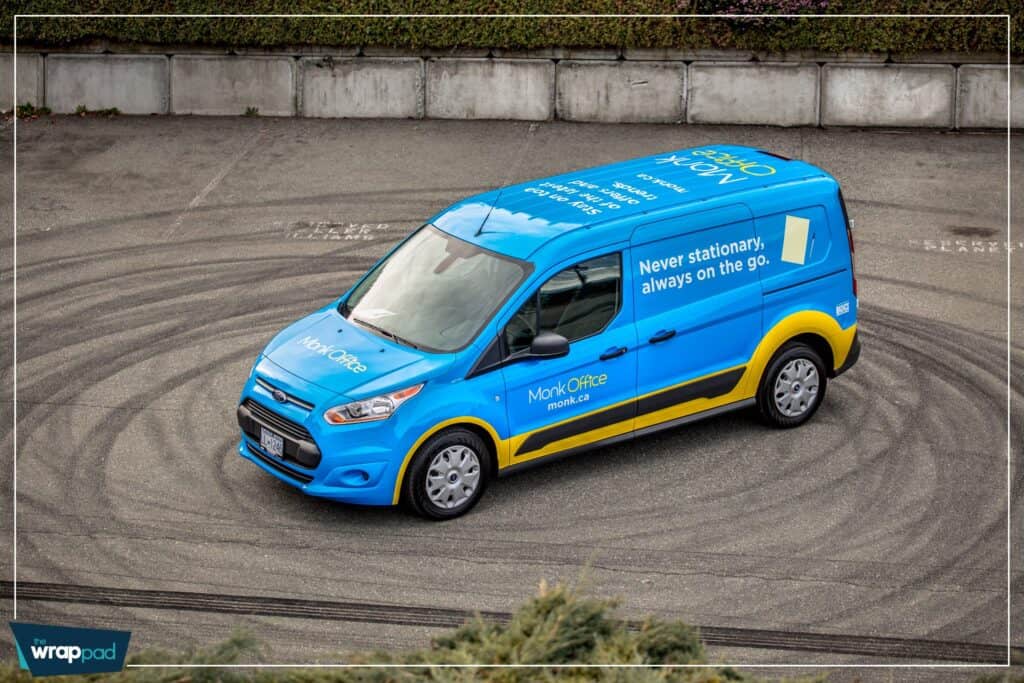 Bright blue advertising van with custom vehicle wrap promoting Monark Care services.