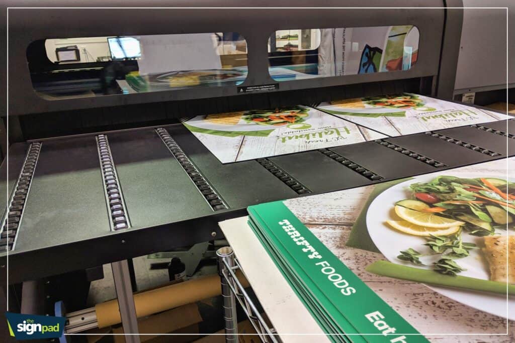 Industrial sign printing machine producing custom signs and vehicle wraps in Victoria.