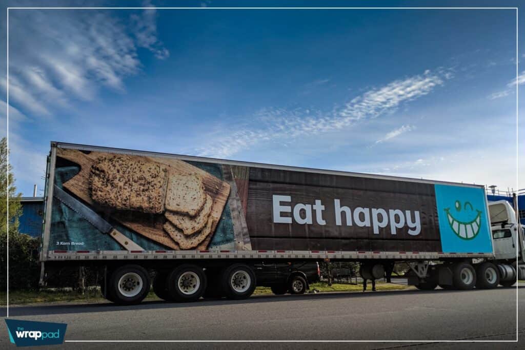 Large vehicle wrap with "Eat happy" message and smiley face in Victoria.