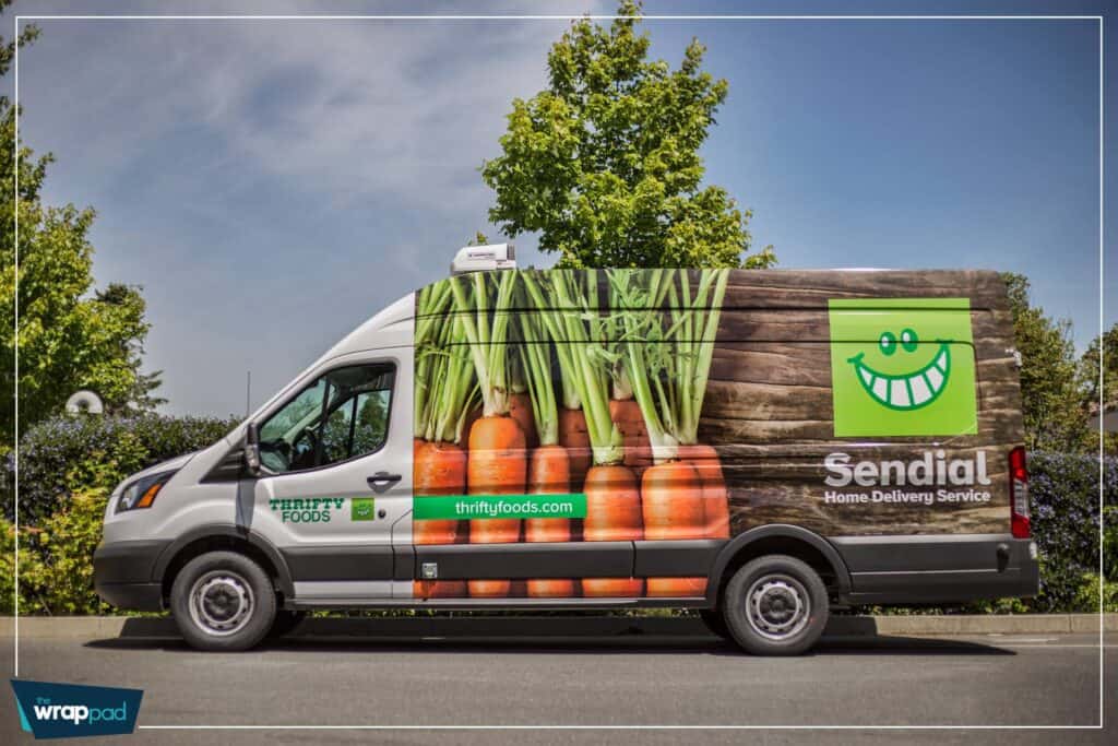 Delivery van with fresh carrots and Sendial logo in a sunny outdoor setting.