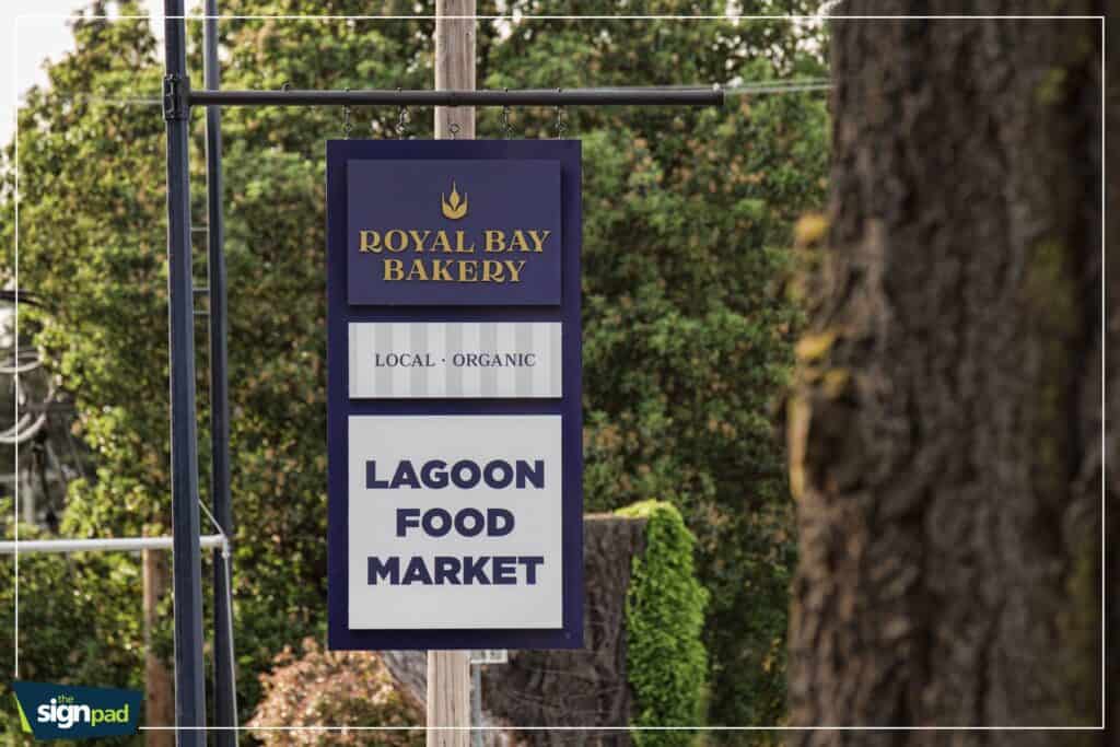 Custom outdoor sign for Royal Bay Bakery promoting local organic products and lagoon food market.