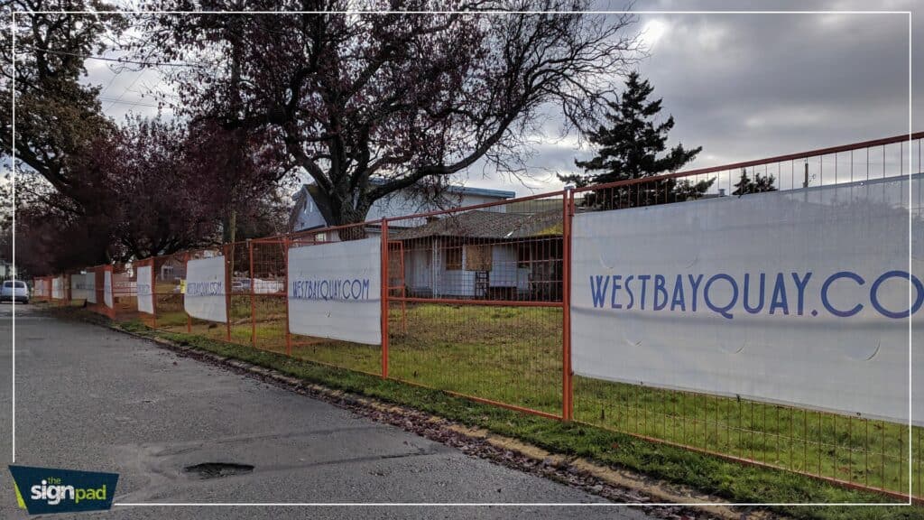 Custom signs and vehicle wraps displayed along a street in Victoria.