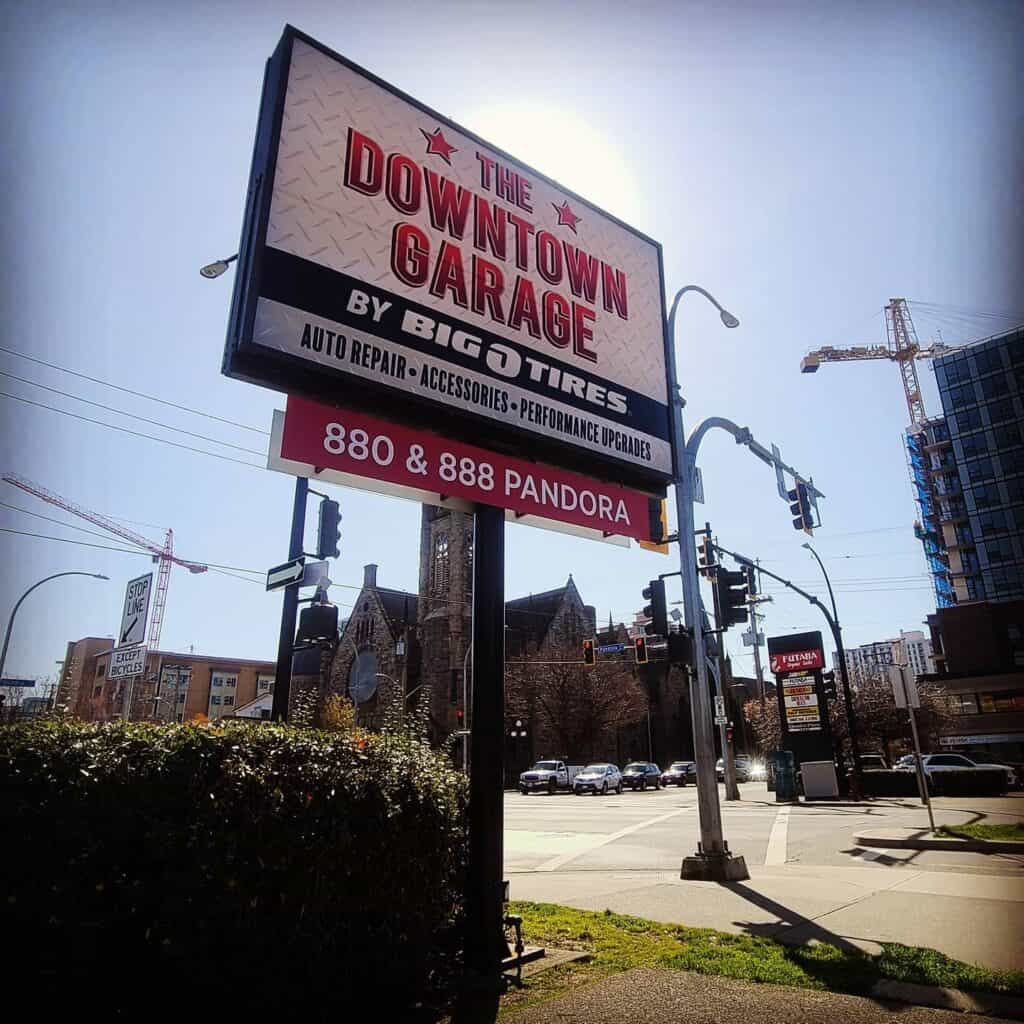 Large outdoor sign for Downtown Garage with contact info and services in Victoria.