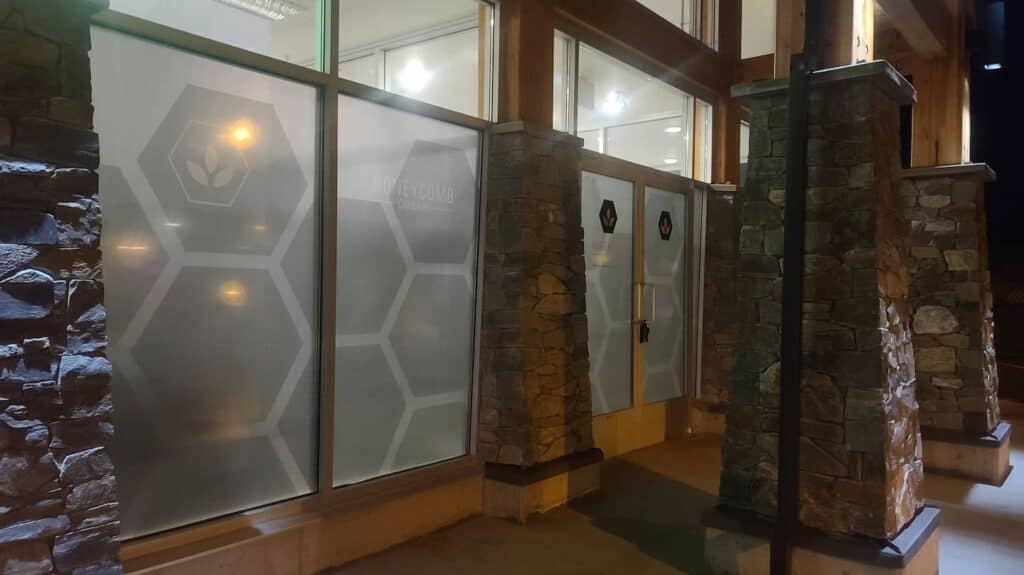 Frosted glass entrance with hexagonal patterns and stone pillars at the office door.