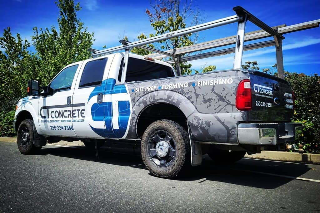 Concrete truck with custom signage for site prep and finishing services.