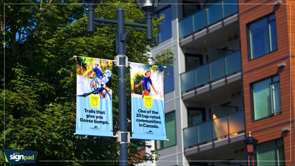 Custom outdoor signs on a street pole promoting community programs.