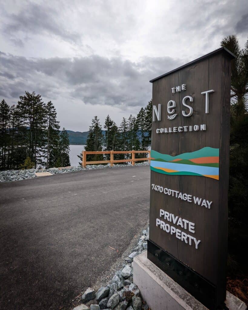 The Nest Collection sign on a scenic lakeside property in Victoria.