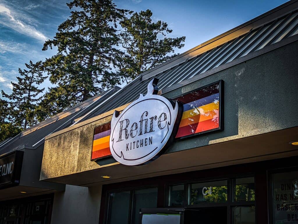Retro Kitchen sign with colorful stripes, mounted on a building exterior.