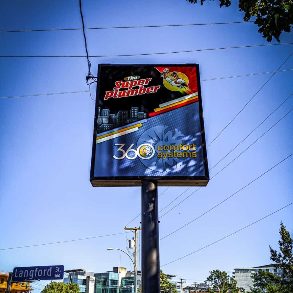 Sign for Super Plumber and Comfort Systems on a tall pole.