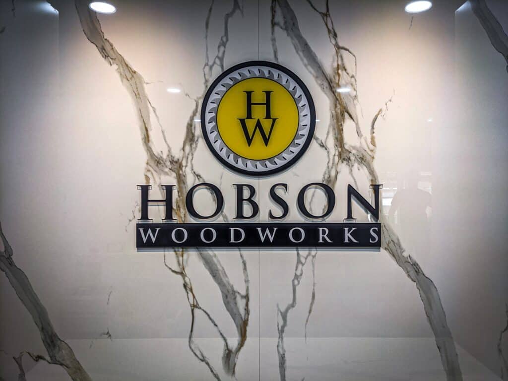 Custom Hobson Woodworks sign on marble wall in Victoria.