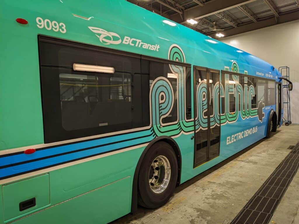 Electric BC Transit bus with custom signage and branding in a vehicle wrap.