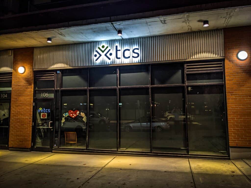 ECS custom sign and vehicle wrap storefront in Victoria at night.