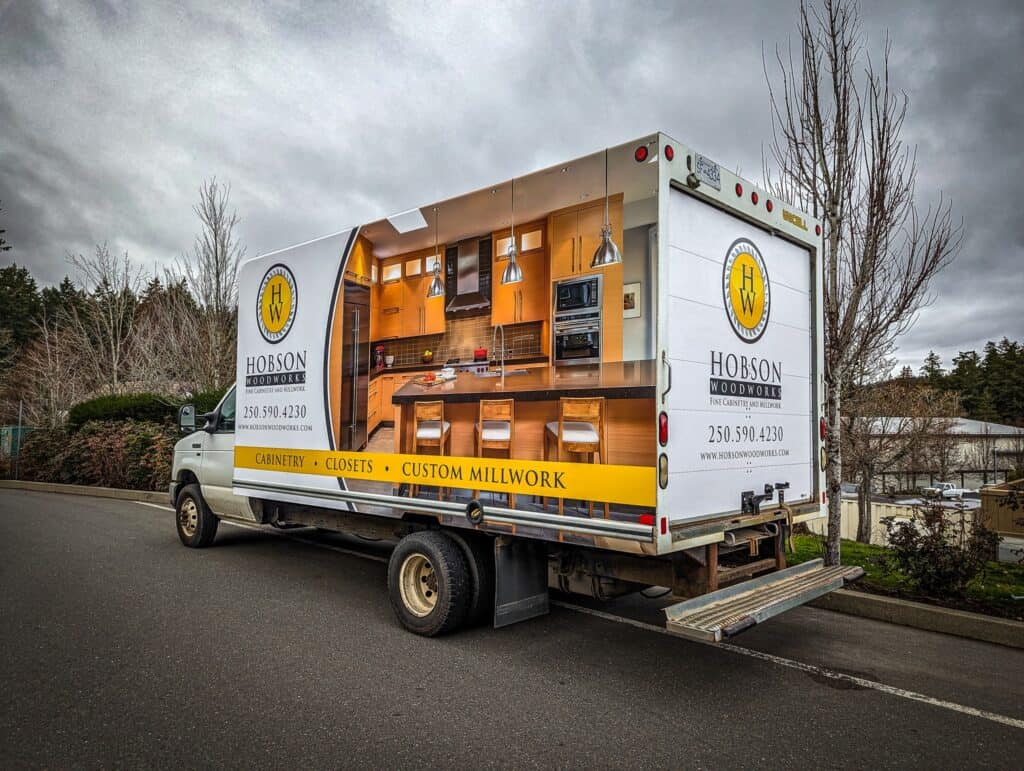Mobile sign truck displaying Hobson Woodworks branding and contact info.