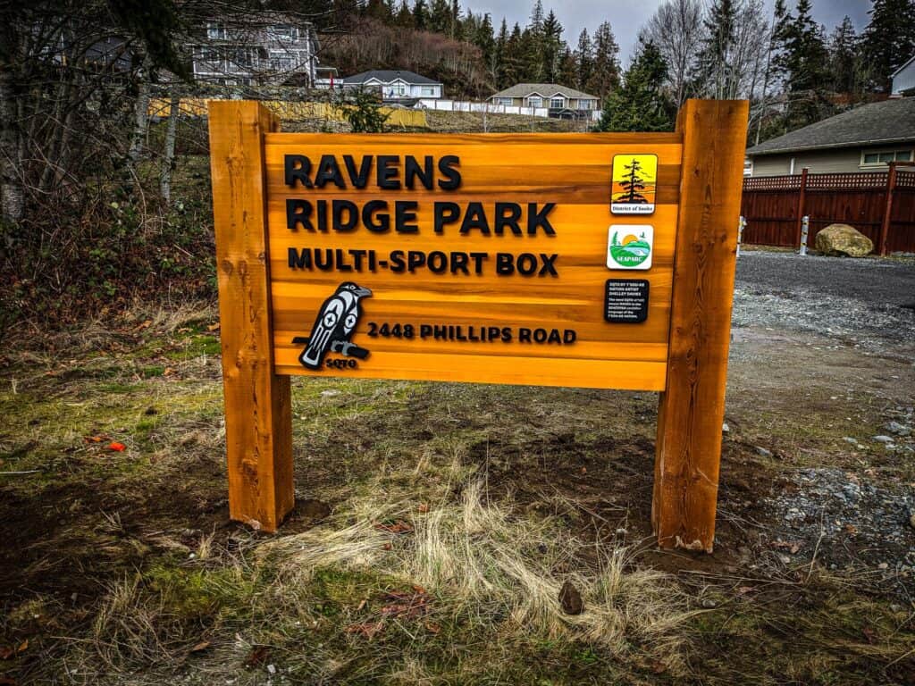 Ravens Ridge Park multi-sport sign with park details and icons, installed on wooden posts.