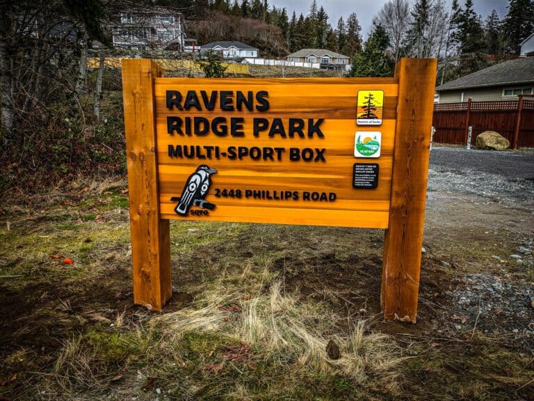 Ravens Ridge Park multi-sport sign with park details and icons, installed on wooden posts.