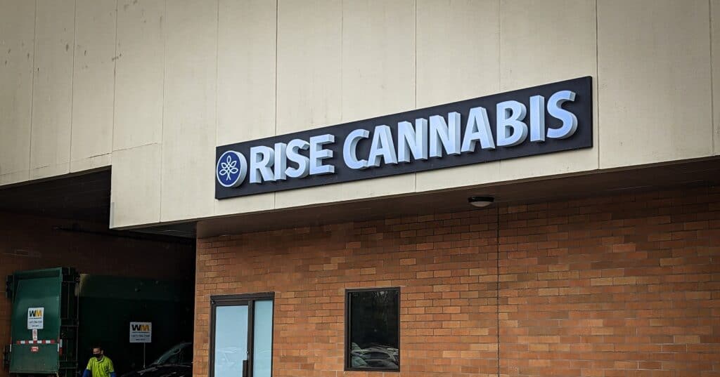 Modern Rise Cannabis storefront sign on brick wall in Victoria.