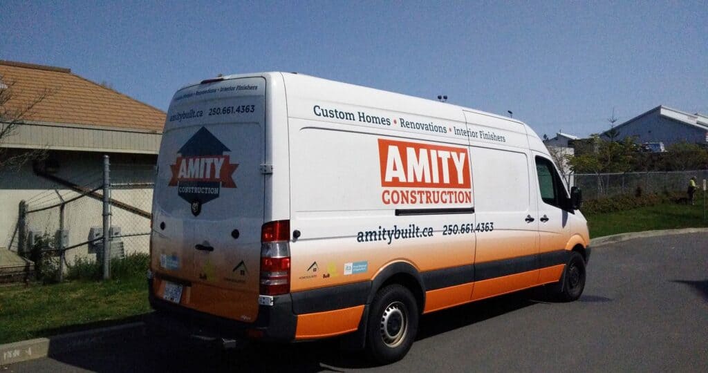 Custom vehicle wrap for Amity Construction on a white van with orange and black branding.