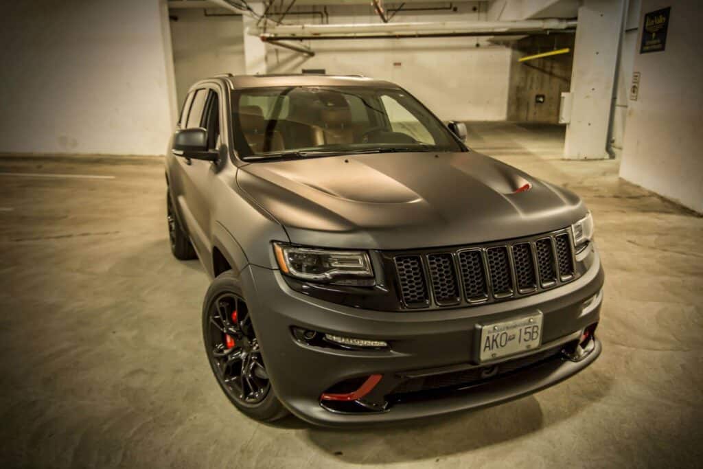 Black Jeep Grand Cherokee parked in an underground parking garage.