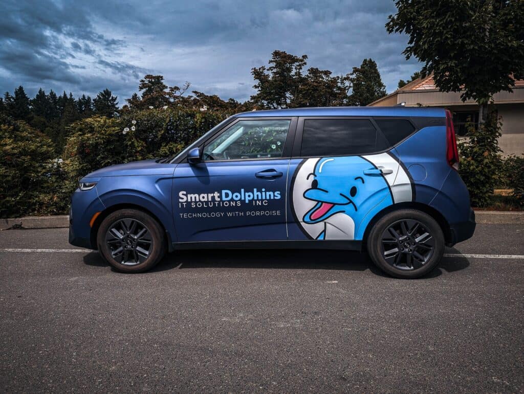 Custom vehicle wrap for Smart Dolphins IT Solutions featuring a playful dolphin graphic.