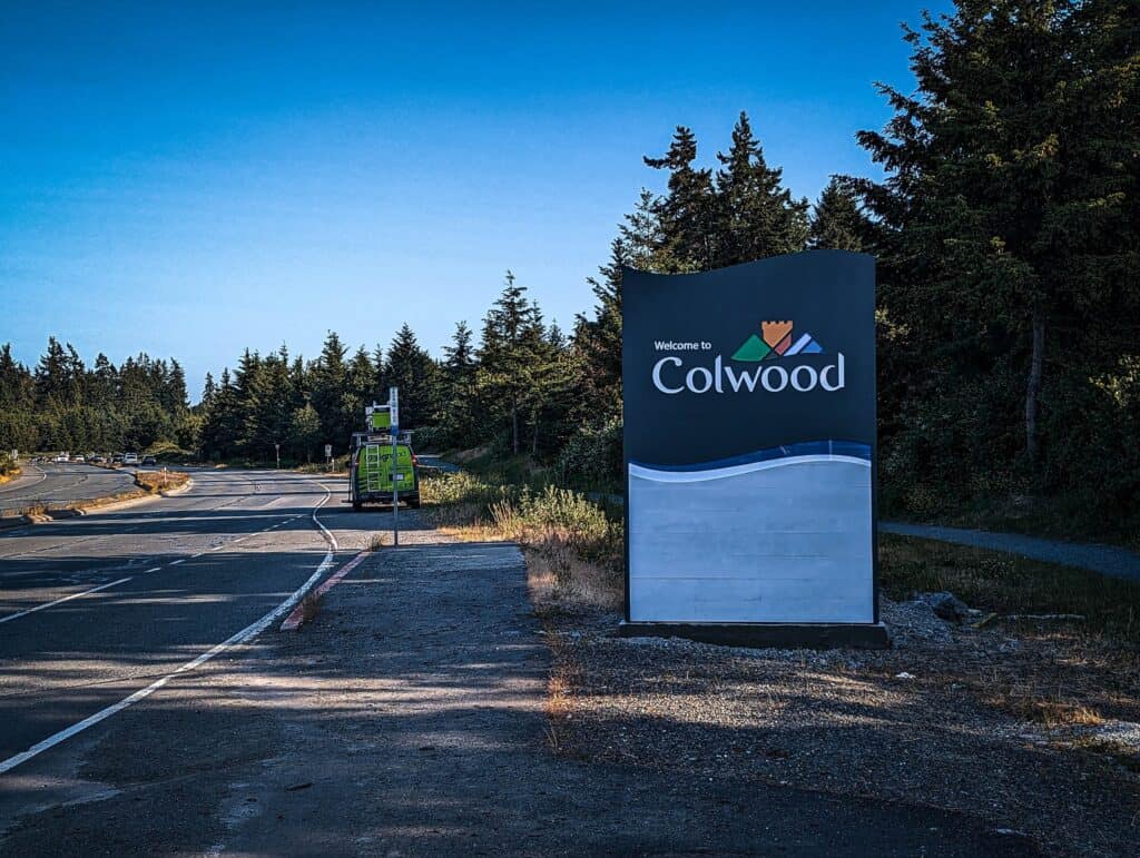 Outdoor welcome sign for Colwood with vibrant logo and message.