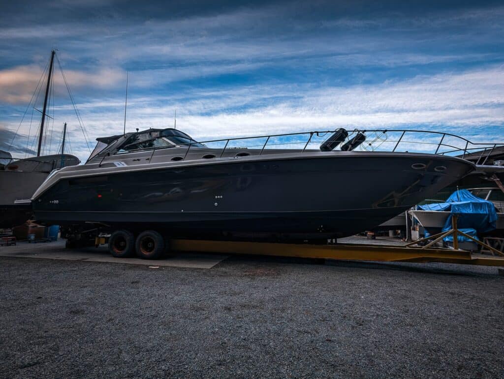 Luxury yacht on trailer at marina, ready for transport.