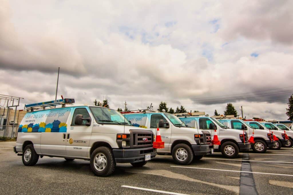 Fleet of gas service vans with custom signs and branding.