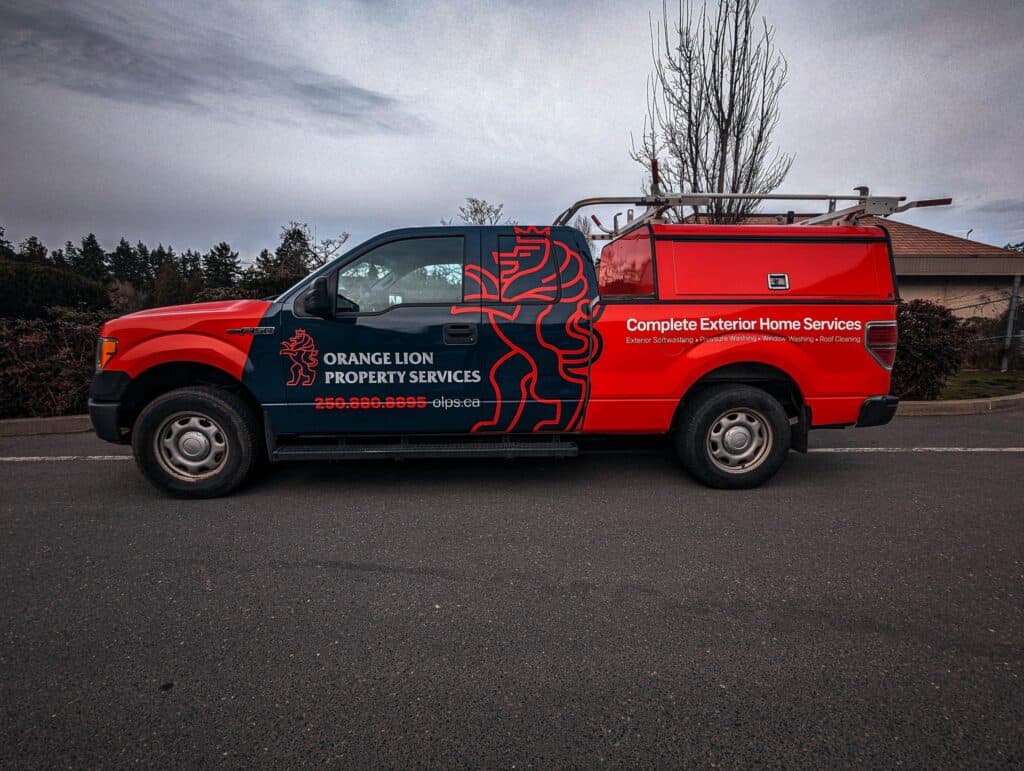 Custom vehicle wrap for Orange Lion Property Services on a red truck.