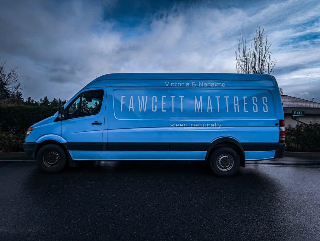 Custom vehicle wrap for Fawcet Mattress on a blue van.
