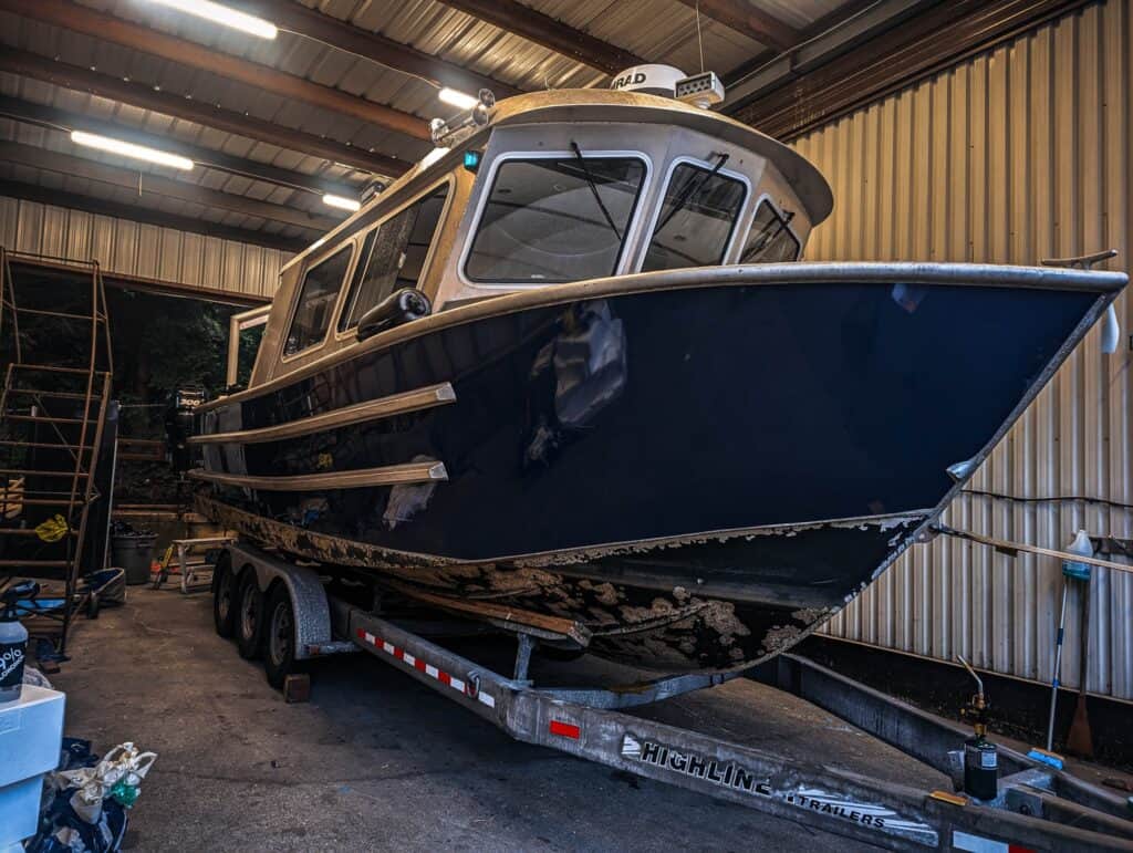 Boat with custom vehicle wrap in a boat storage facility.