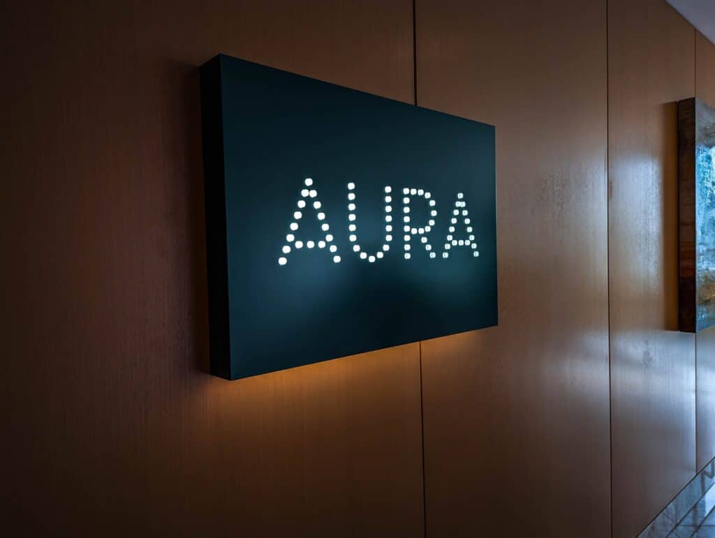 Aura Sign with illuminated text on a dark background.