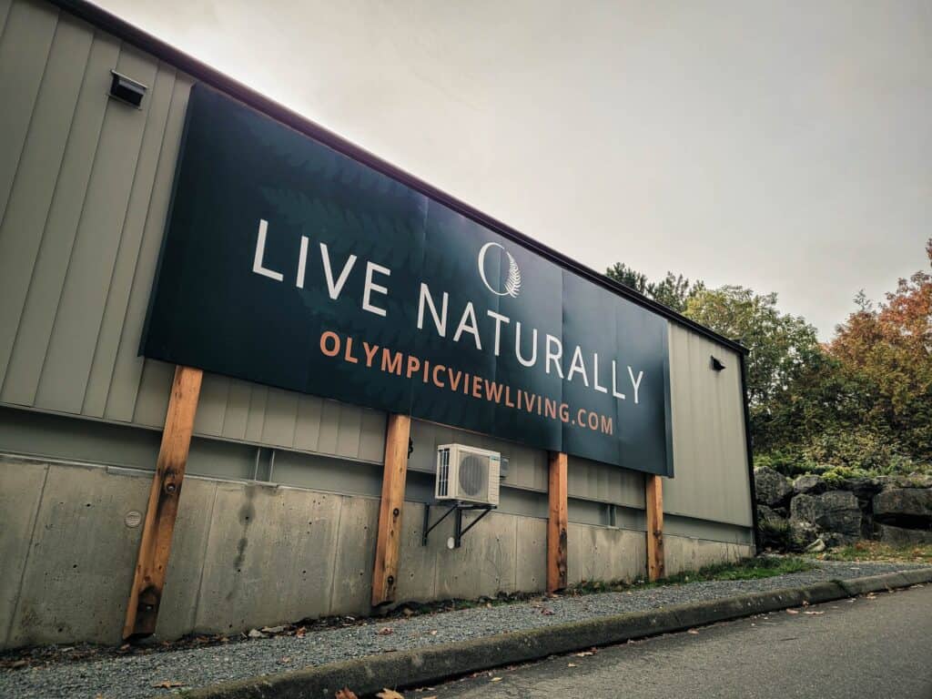 Large outdoor sign displaying "Live Naturally" with website URL for promotion.