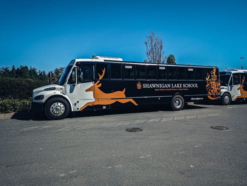 Custom school bus wrap for Shawningan Lake School in Victoria, featuring a deer graphic and school b.
