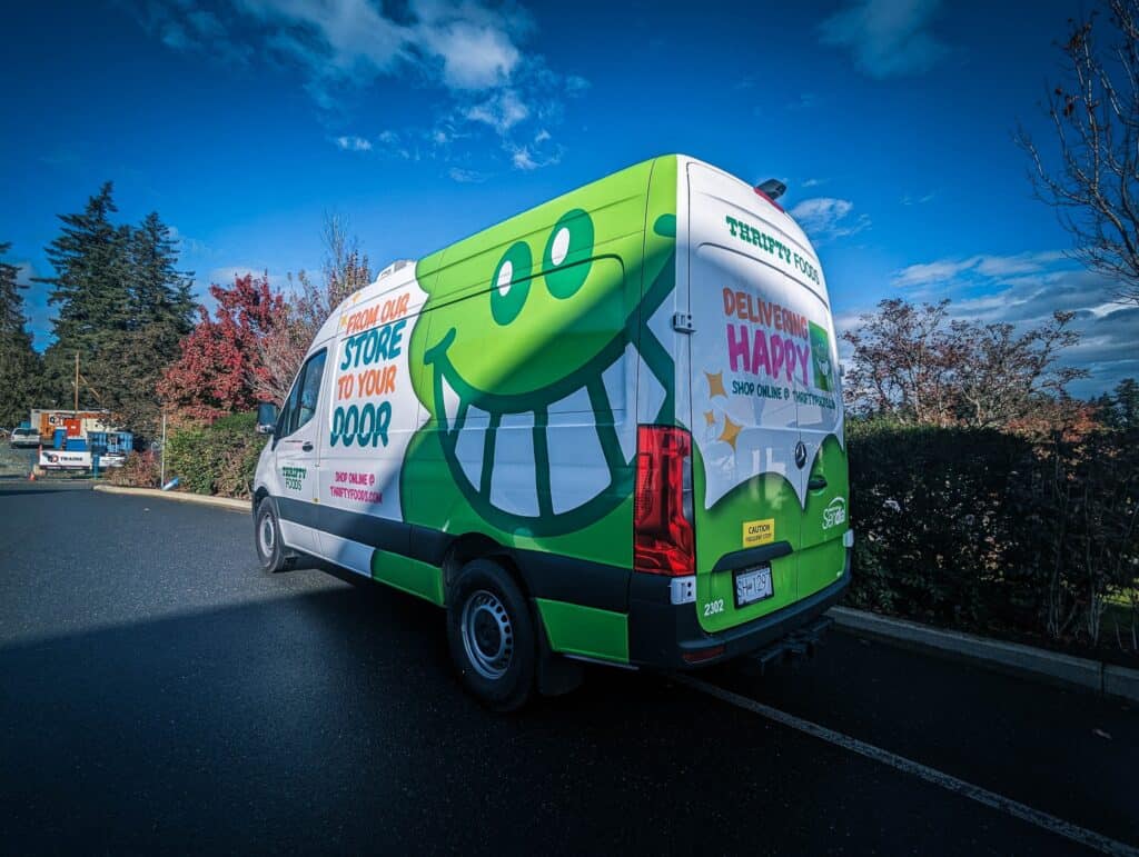 Vehicle wrap featuring a large, cheerful smiley face for branding and advertising.