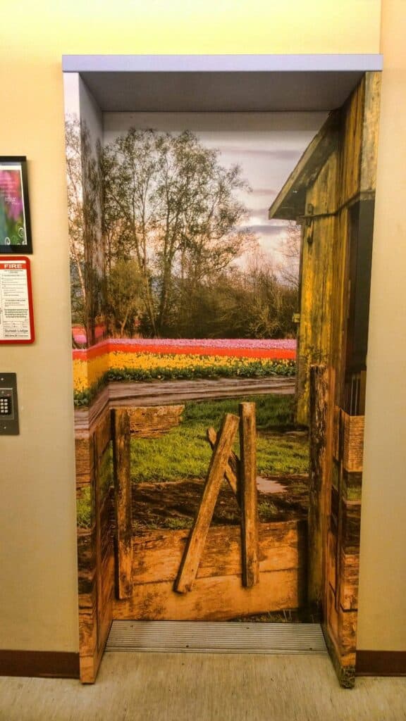 Custom wooden sign door wrap with rustic design and natural wood finish.