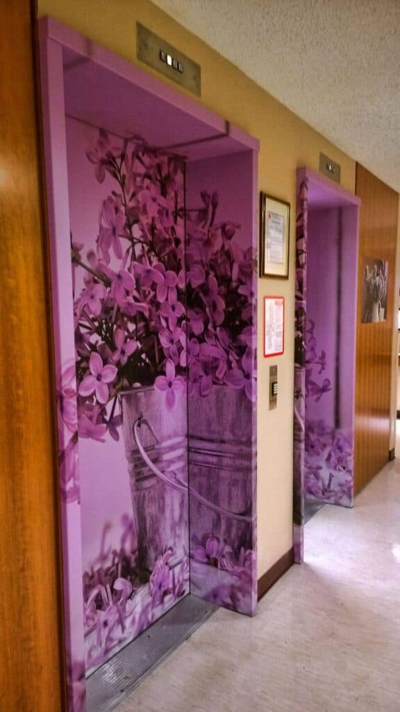 Elevator doors featuring a purple floral pattern with a matching interior panel.
