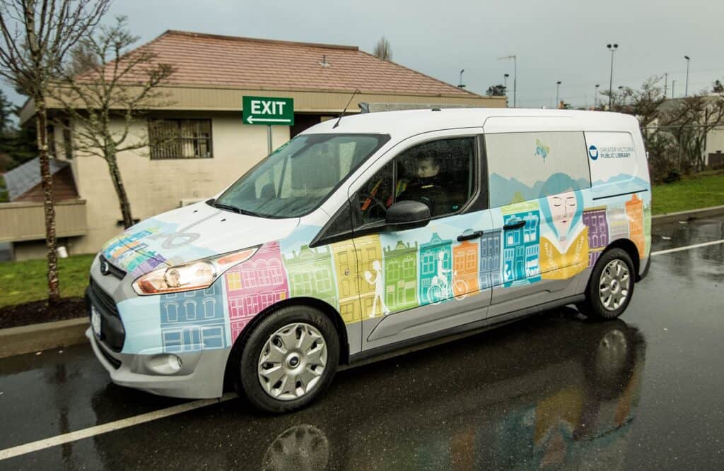 Vehicle wrap with colorful signs and graphics for advertising.