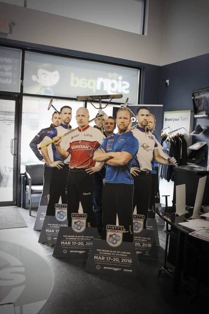 Life-size cardboard cutouts of sports team members in a retail store.