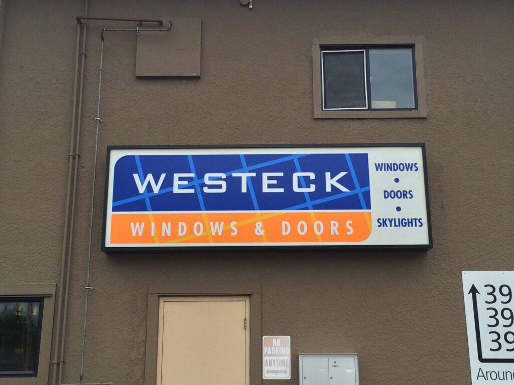 Exterior sign for Westeck Windows & Doors on building wall.