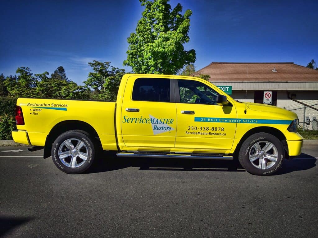 ServiceMASTER Restore vehicle with custom signage and contact details.