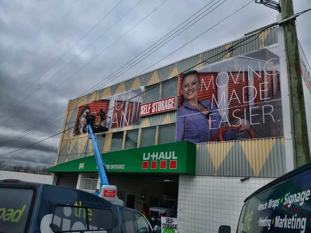 Large U-Haul sign on building with moving and storage services.