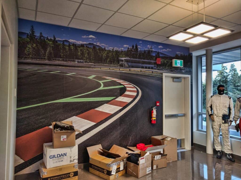 Sign pad wall mural showcasing a racing track scene at Victoria custom signage shop.
