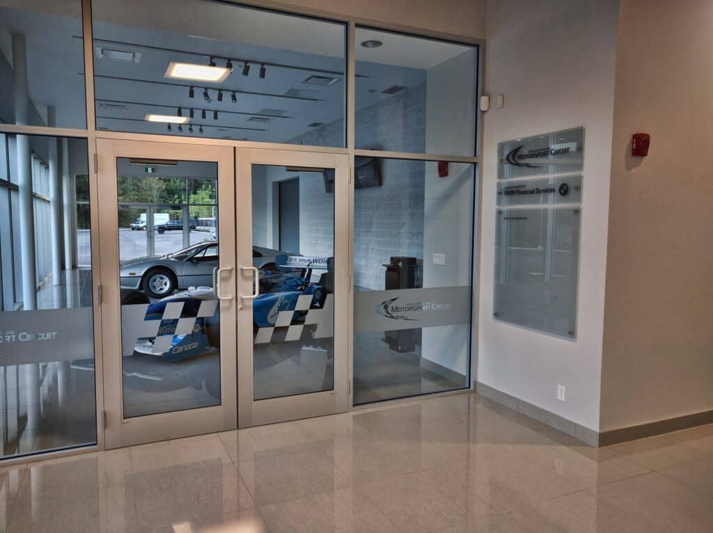 Sign Pad Entrance with glass doors and vehicle display inside.