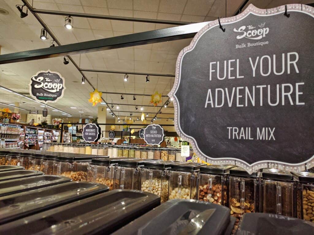 Bulk trail mix display with a sign saying "Fuel Your Adventure" in store.