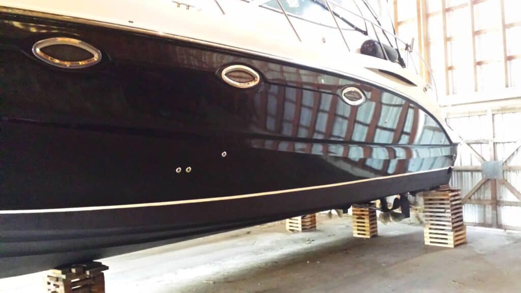 Boat with custom signs and vehicle wraps in a warehouse setting.