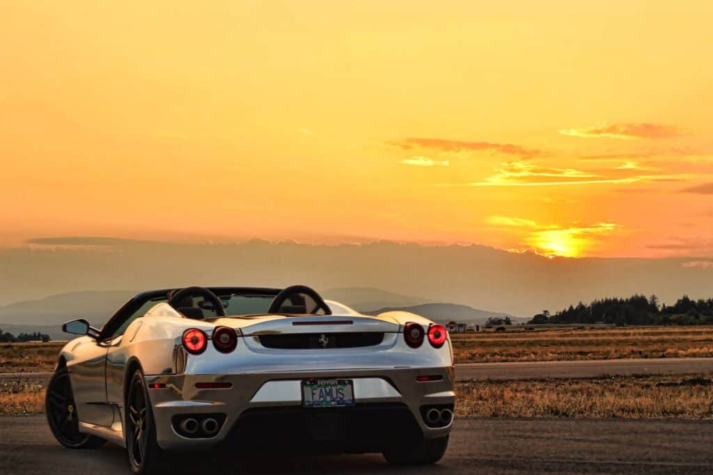 Luxury sports car parked during sunset with scenic background.
