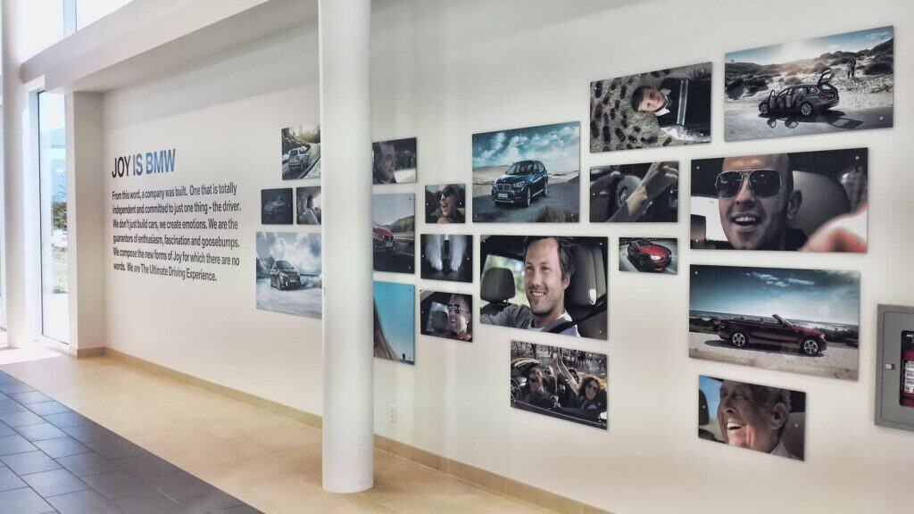 Collection of car photos and customer smiles at Outqtrlg Victoria showroom.