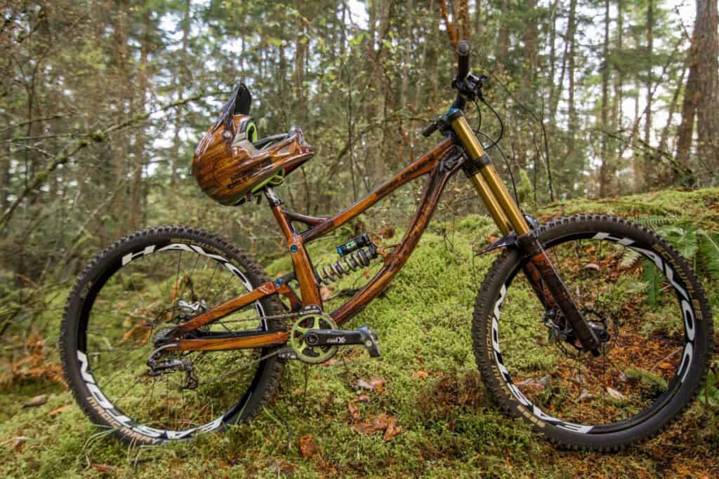 Custom mountain bike with helmet in forest setting, showcasing outdoor adventure gear.