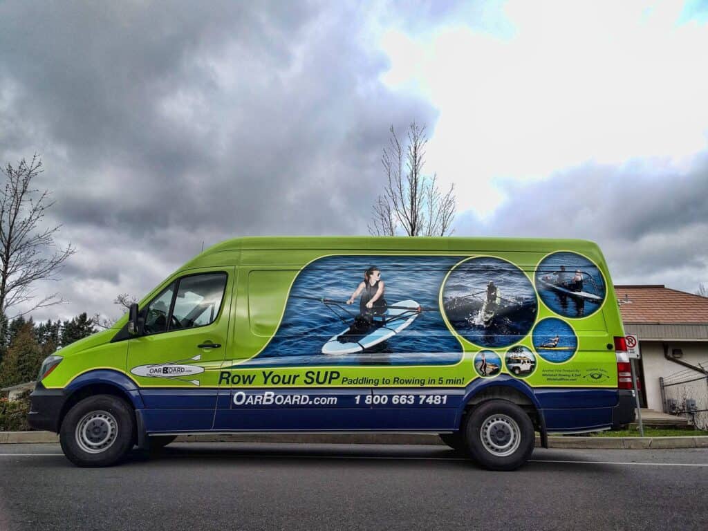 Vehicle wrap advertising paddleboarding services.