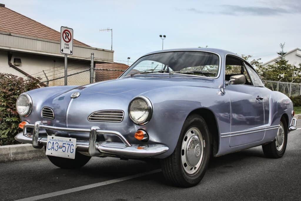 Vintage Volkswagen Karmann Ghia car parked on street.